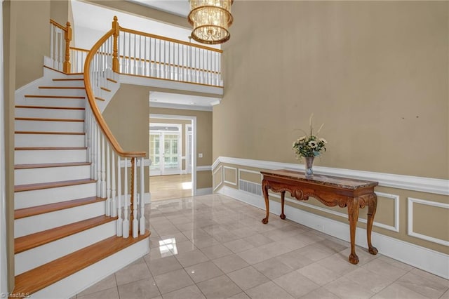 tiled entrance foyer with an inviting chandelier and a towering ceiling