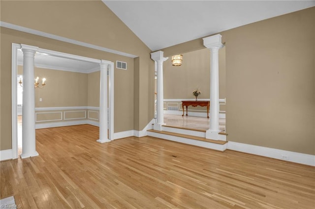 interior space with wood-type flooring, a notable chandelier, decorative columns, and high vaulted ceiling