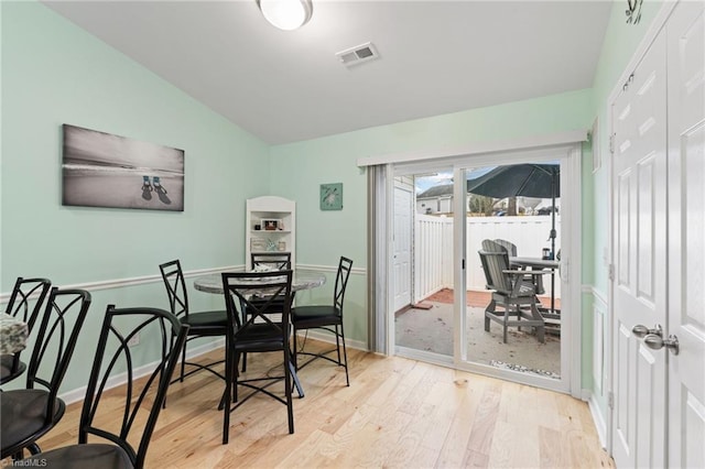 dining area with lofted ceiling and light hardwood / wood-style floors