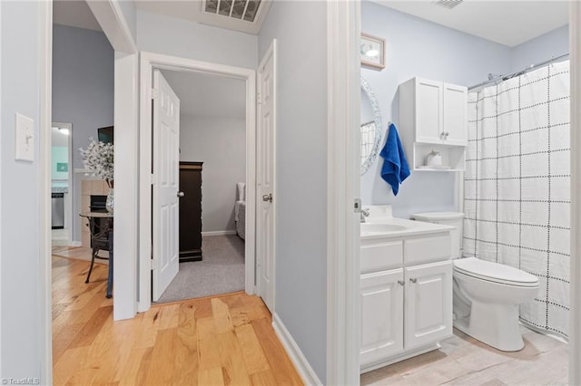 bathroom featuring a shower with shower curtain, toilet, vanity, and hardwood / wood-style flooring