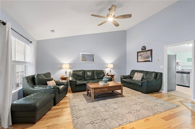 living room with ceiling fan, light hardwood / wood-style flooring, and lofted ceiling