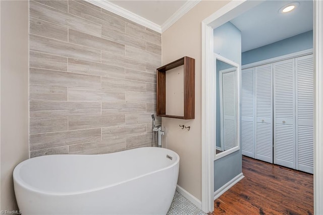 bathroom featuring ornamental molding, hardwood / wood-style floors, and a bathtub