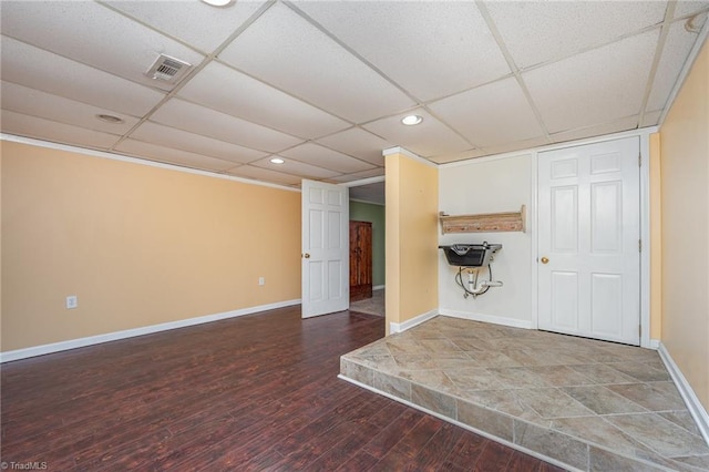 interior space with a paneled ceiling and hardwood / wood-style floors