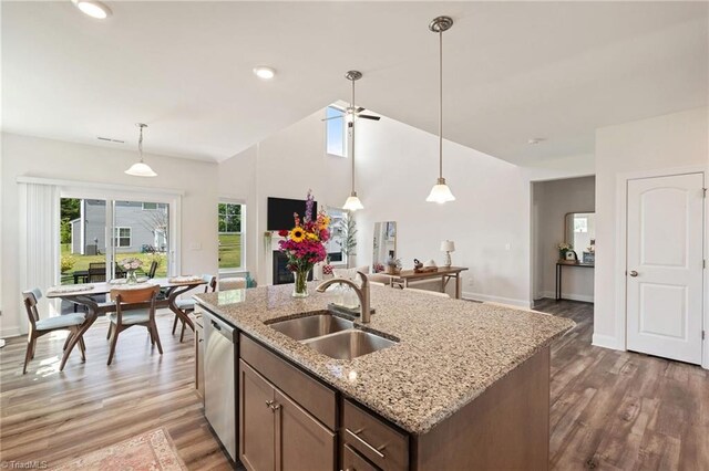4077 Glenn Knoll Ln, Winston-Salem, NC 27107 - kitchen featuring a sink, dishwasher, vaulted ceiling, decorative light fixtures, and light wood-style floors