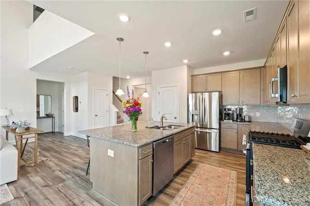 4077 Glenn Knoll Ln, Winston-Salem, NC 27107 - kitchen with appliances with stainless steel finishes, a sink, light wood-style flooring, light stone countertops, and a breakfast bar area