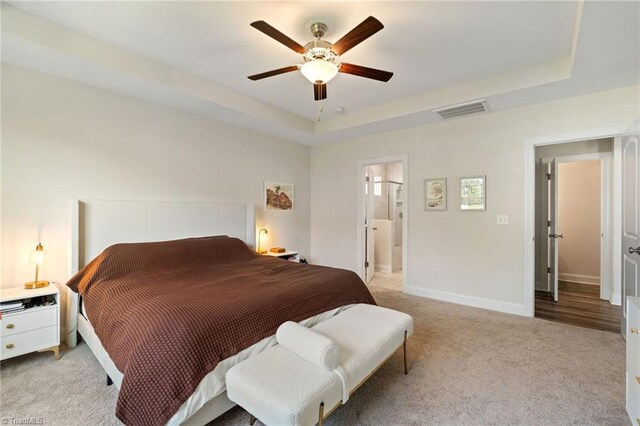 4077 Glenn Knoll Ln, Winston-Salem, NC 27107 - bedroom with light colored carpet, a tray ceiling, baseboards, ceiling fan, and ensuite bath