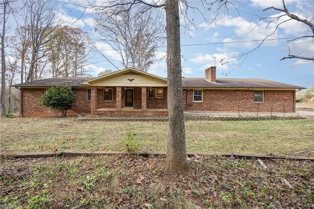 rear view of property featuring covered porch and a yard