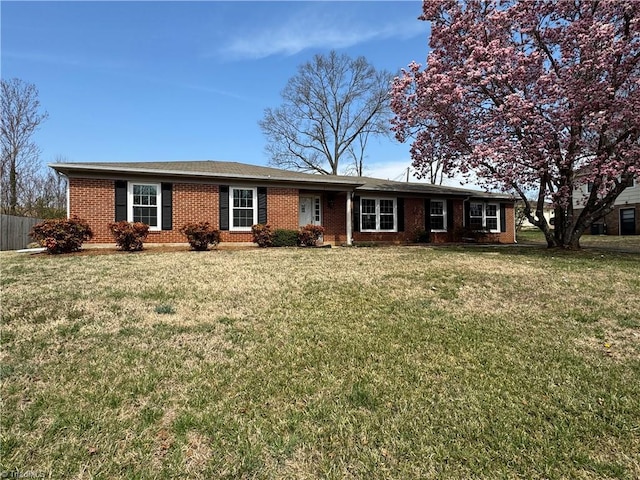 ranch-style home featuring brick siding and a front lawn