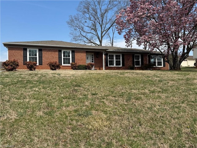 ranch-style home featuring a front yard and brick siding