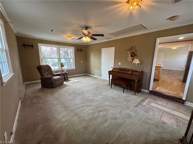 sitting room featuring visible vents, attic access, ornamental molding, light carpet, and a ceiling fan