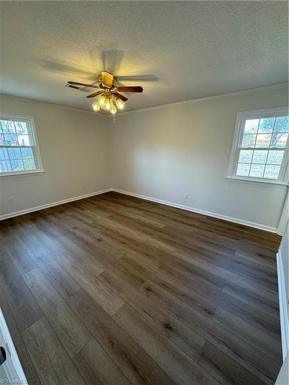 spare room with a textured ceiling, dark wood-type flooring, ornamental molding, and ceiling fan