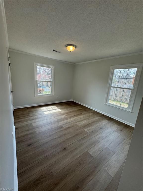 empty room featuring dark wood finished floors and ornamental molding