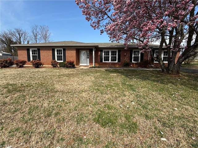 ranch-style house featuring brick siding and a front lawn