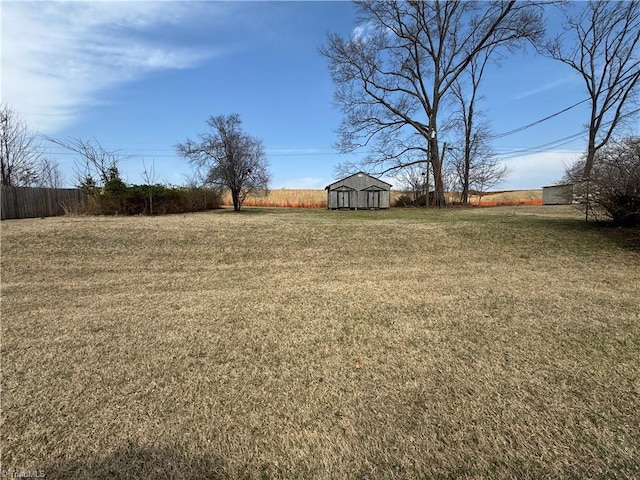 view of yard with a storage unit, an outbuilding, and fence