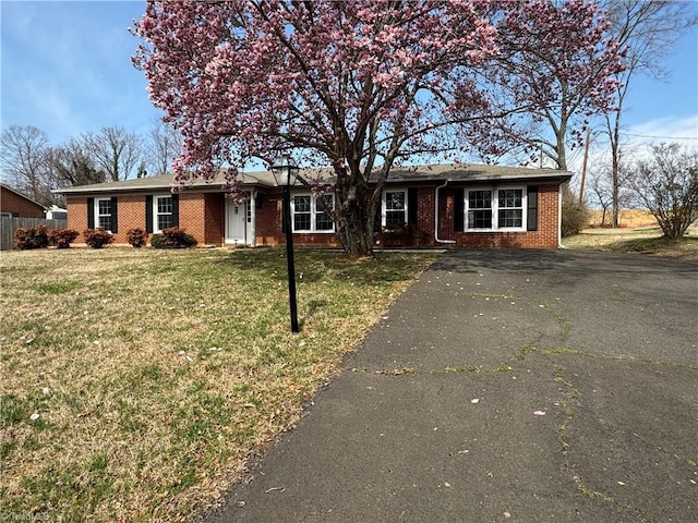 ranch-style house with brick siding, driveway, and a front yard