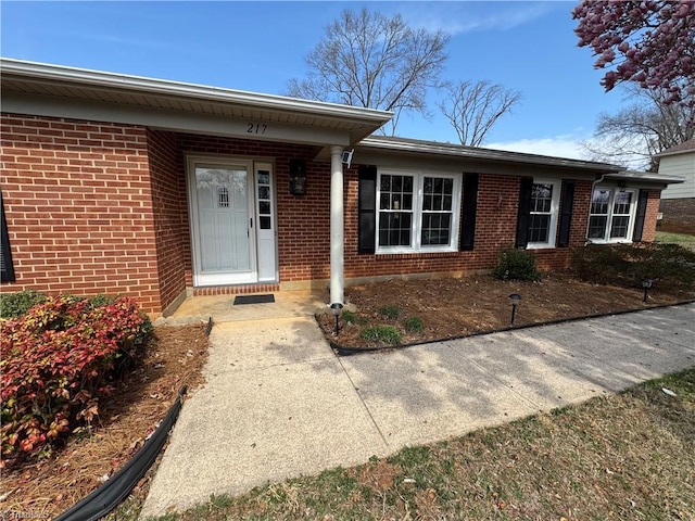 doorway to property featuring brick siding