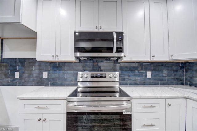 kitchen featuring tasteful backsplash, light stone counters, white cabinets, and stainless steel appliances