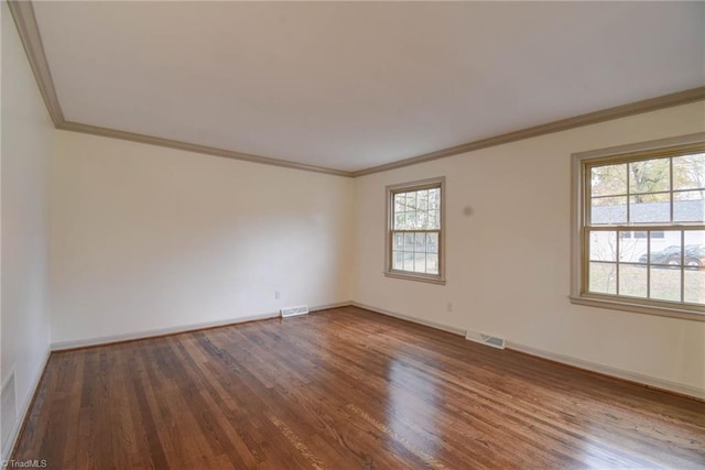 spare room featuring ornamental molding and dark wood-type flooring