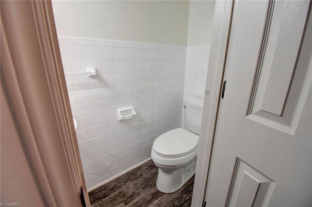 bathroom featuring hardwood / wood-style floors, tile walls, and toilet