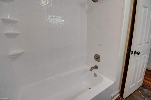 bathroom featuring tile patterned flooring and tiled shower / bath