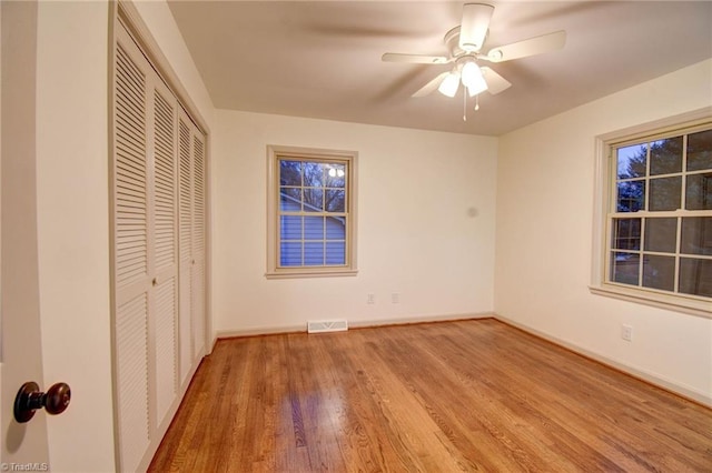 unfurnished bedroom with ceiling fan, a closet, and wood-type flooring