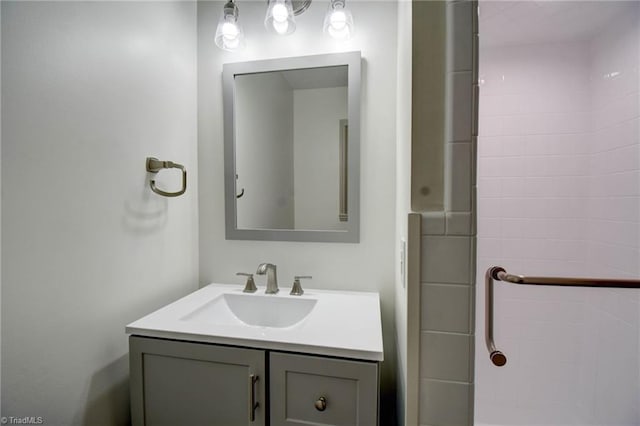 bathroom with vanity and a tile shower