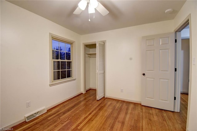 unfurnished bedroom featuring ceiling fan, light hardwood / wood-style floors, and a closet