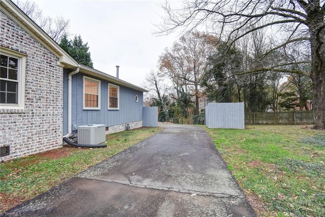 view of property exterior featuring a lawn and central AC