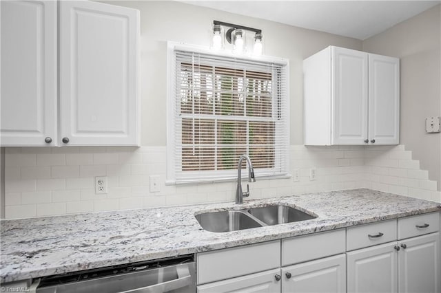 kitchen with a sink, white cabinetry, decorative backsplash, and stainless steel dishwasher