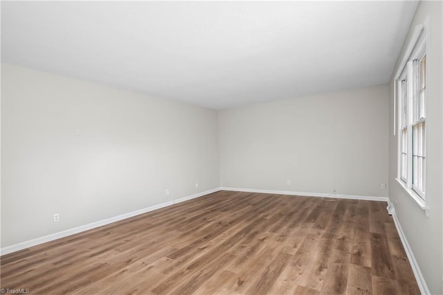 spare room featuring wood finished floors and baseboards