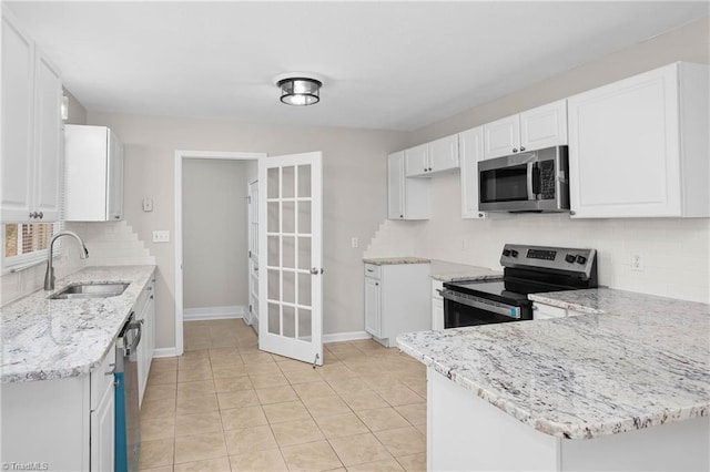 kitchen with white cabinetry, appliances with stainless steel finishes, light stone counters, and a sink