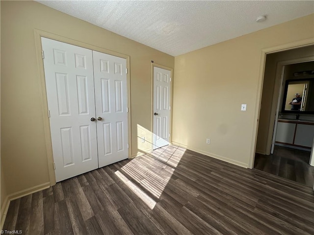 unfurnished bedroom featuring dark wood-type flooring, a closet, and a textured ceiling