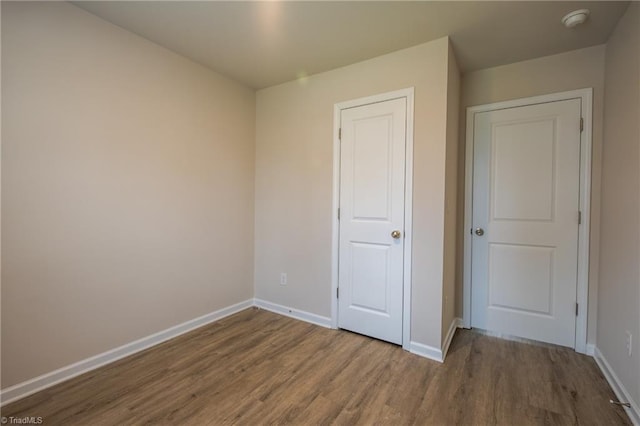 unfurnished bedroom with baseboards and wood finished floors