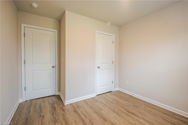 unfurnished bedroom featuring light wood-type flooring and baseboards