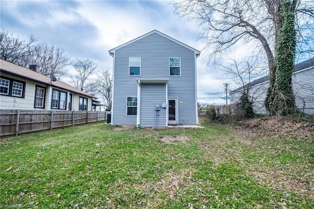 back of house with a lawn and fence