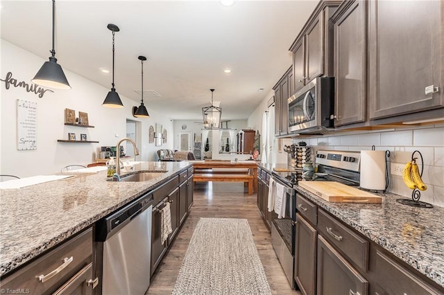5838 Springer Dr, Greensboro, NC 27405 - kitchen with stainless steel appliances, a sink, dark wood finished floors, dark brown cabinets, and recessed lighting