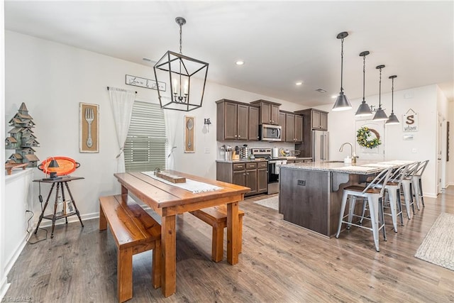 5838 Springer Dr, Greensboro, NC 27405 - dining room with wood finished floors, stairway, baseboards, recessed lighting, and a chandelier