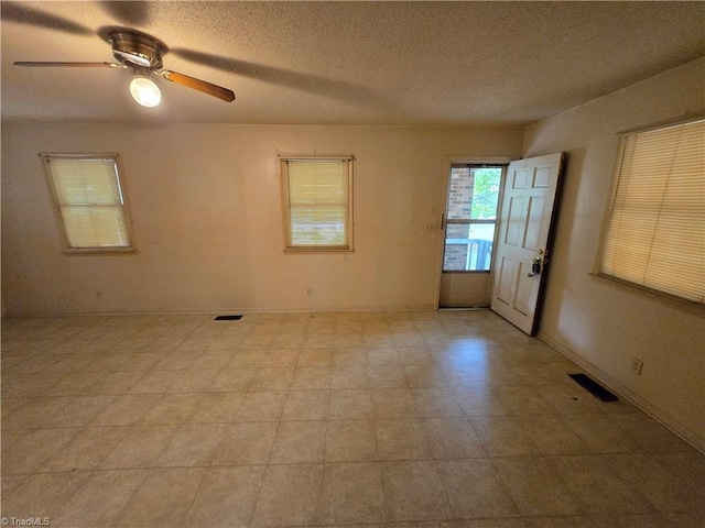 spare room featuring a textured ceiling and ceiling fan