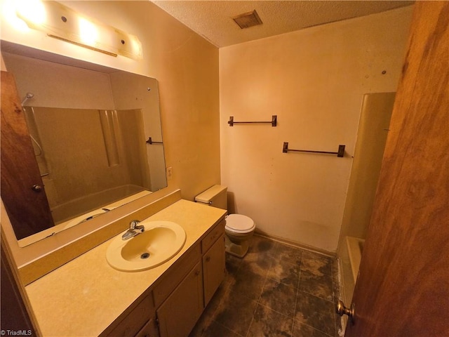 full bathroom featuring washtub / shower combination, a textured ceiling, vanity, and toilet