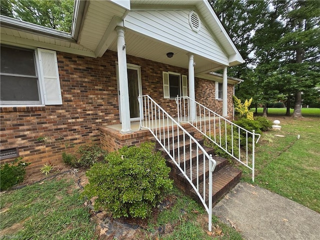 property entrance with a yard and a porch