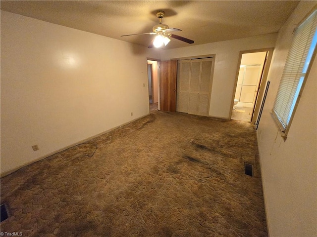 unfurnished bedroom with a closet, carpet, ceiling fan, and a textured ceiling