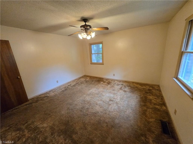 spare room featuring carpet, ceiling fan, a healthy amount of sunlight, and a textured ceiling