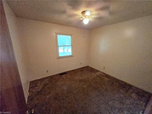 empty room featuring a textured ceiling, carpet, and ceiling fan