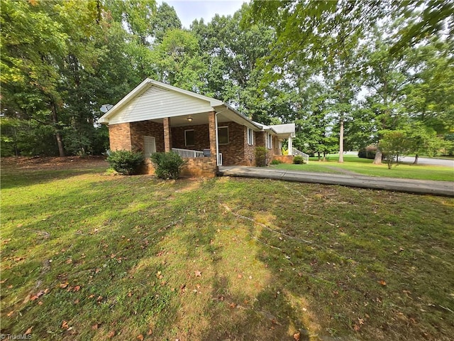 view of side of property with covered porch and a yard