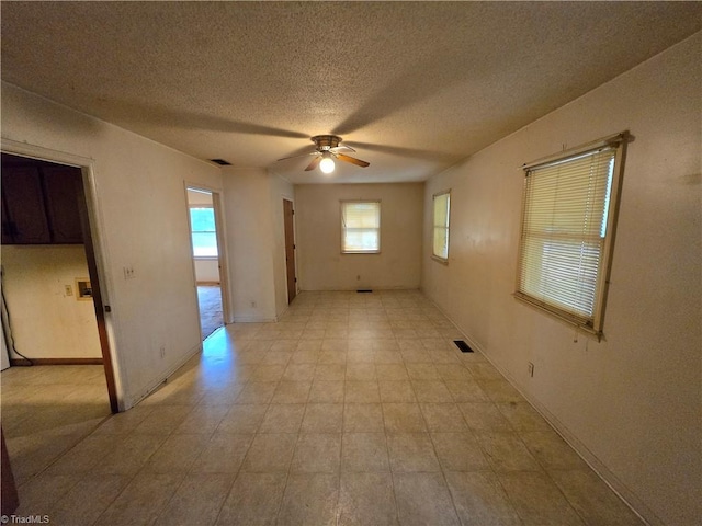 unfurnished room featuring ceiling fan and a textured ceiling