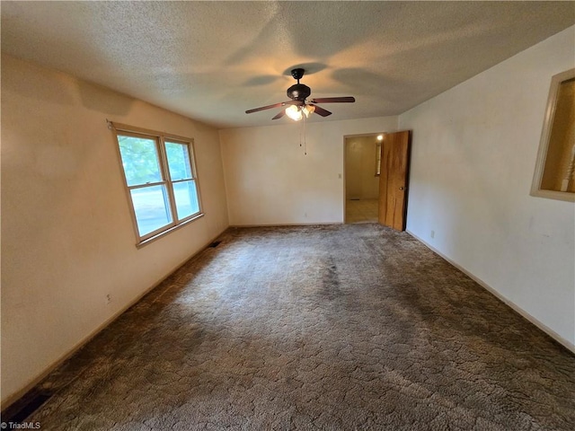 carpeted spare room featuring ceiling fan and a textured ceiling