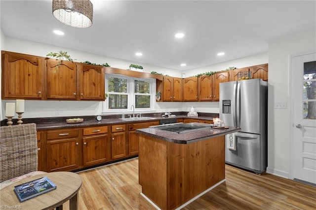 kitchen with sink, light hardwood / wood-style flooring, a center island, stainless steel refrigerator with ice dispenser, and black cooktop