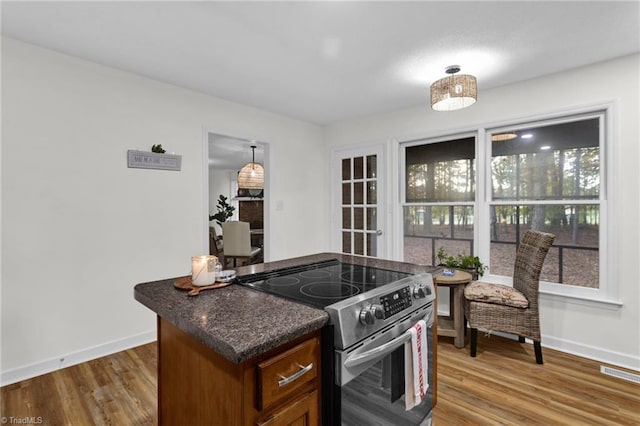 kitchen featuring electric stove, pendant lighting, and wood-type flooring