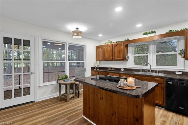 kitchen with sink, light hardwood / wood-style flooring, dishwasher, a kitchen island, and stainless steel gas stovetop