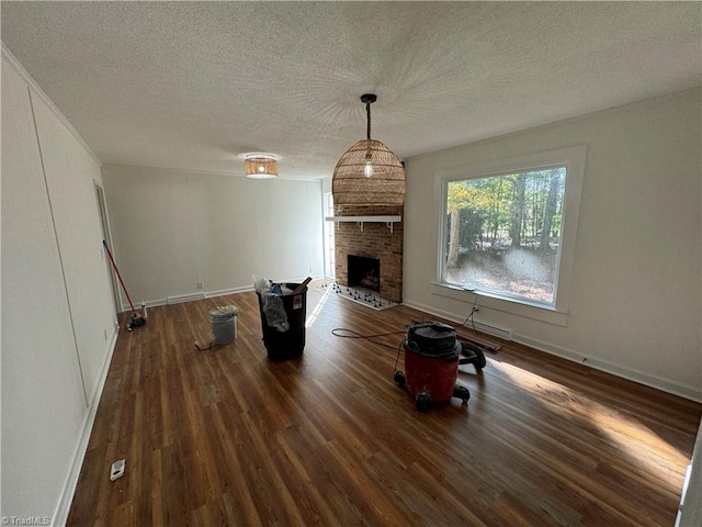 unfurnished living room featuring dark hardwood / wood-style floors, a fireplace, and a textured ceiling